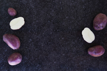 Obraz na płótnie Canvas Purple potatoes background with reflections. Copy space.