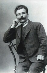 Ukraine, Europe 1910th . Caucasian man with mustache in costume sit on chair. Black white vintage retro photo. Old scanned monochrome portrait. Blurred photo © virginna
