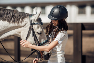 Young teenage girl equestrian having fun with her favorite horse. Dressage outfit