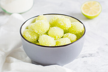 Sour candy grapes in a bowl, lime and sugar for cooking. Social media candy trend. Close-up