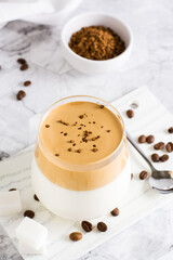 Dalgona coffee - trendy iced Korean coffee in a glass on the table. Social media drink. Vertical view