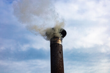 Iron chimney, chimney and smoke against the sky