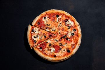 Tomato-based pizza with mozzarella cheese, hunting sausages, salami, olives, mushroom sauce on black background
