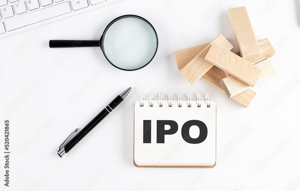 Poster notebook with the word ipo with keyboard and calculator on the white background