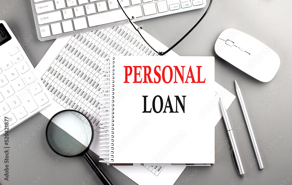 Poster personal loan text on notepad on chart with keyboard and calculator on grey background