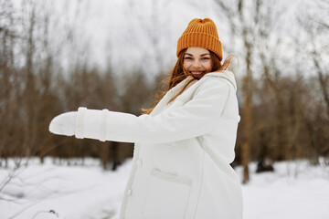 Happy young woman in winter clothes in a hat fun winter landscape fresh air