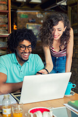 Woman and man students study in the coffee shop using laptop and tablet