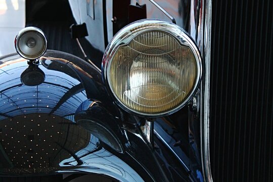 Detail of round front light and part of the fender and front mask of veteran car Packard Light Eight, produced in year 1932 by Packard Motor Car Company in Detroit, Michigan.