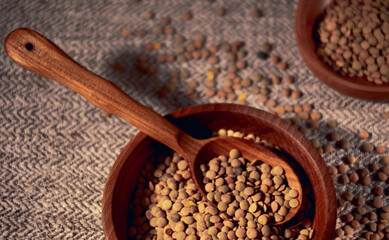 Lentils in a wooden bowl with a wooden spoon