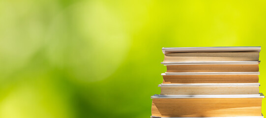 stacked books on green natural background