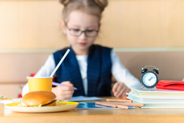 schoolchild doing homework, studing at school. girl waiting for lunch break at school. improper...