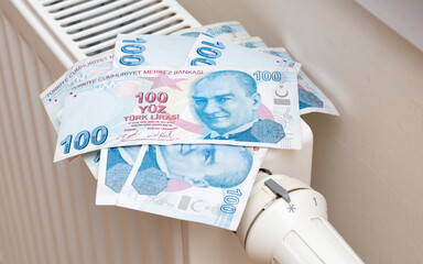 Fototapeta na wymiar Turkish lira banknotes in a central heating radiator, the concept of expensive heating costs, close-up