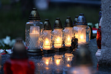 Świeczka na grobie osoby bliskiej świeci podczas święta zmarłych. 