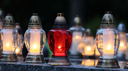 Świeczka na grobie osoby bliskiej świeci podczas święta zmarłych.  - obrazy, fototapety, plakaty