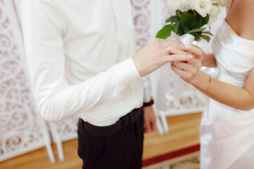 Newlyweds exchange wedding rings. The bride rings the groom. Wedding ceremony. The concept of a strong family. The concept of a marriage contract.