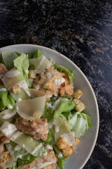 Ensalada cesar sobre fondo marmol
