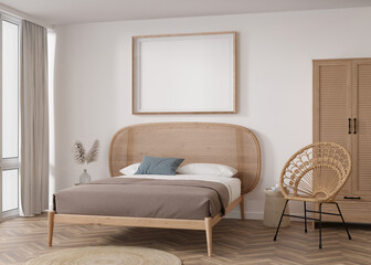 Empty horizontal picture frame on white wall in modern bedroom. Mock up interior in boho style. Free, copy space for your picture, poster. Bed, rattan armchair, pampas grass. 3D rendering.