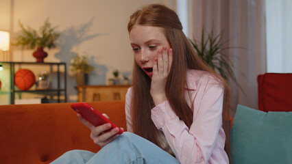 Oh my God, Wow. Happy excited teen young child girl use mobile smartphone typing browsing say yes...