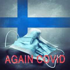 Lettering Again Covid and a crumpled medical mask on the flag of Finland. Return of the...
