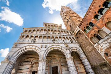 The three arches and tower of the Saint Martin Cathedral in the historic walled town of Lucca, Italy. - obrazy, fototapety, plakaty