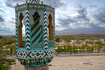 Detail shot of colorful tiles on mosque minaret. Greenminaret of Vali Shrine mosque viewed from a...