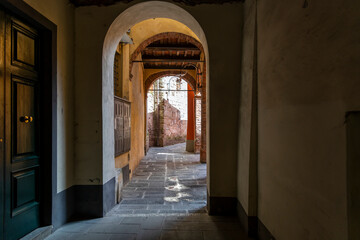 Naklejka premium A covered portico alley in the historic center of the Tuscan walled city of Lucca, Italy.