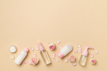 Set of small cosmetic bottles on color background, top view