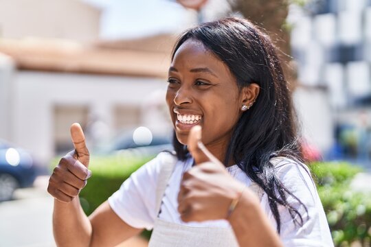 Young african american woman smiling confident doing ok sign with thumbs up at park