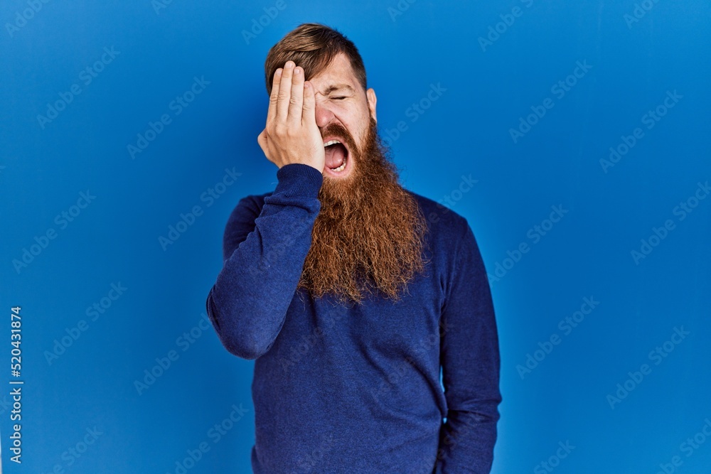 Canvas Prints redhead man with long beard wearing casual blue sweater over blue background yawning tired covering 