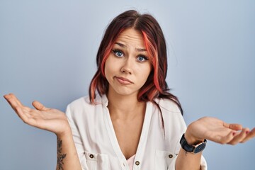 Young caucasian woman wearing casual white shirt over isolated background clueless and confused...