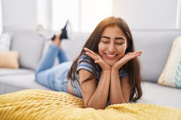 Obraz na płótnie Canvas Young hispanic girl smiling confident lying on sofa at home
