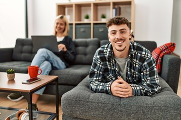 Young caucasian couple smiling happy at home.