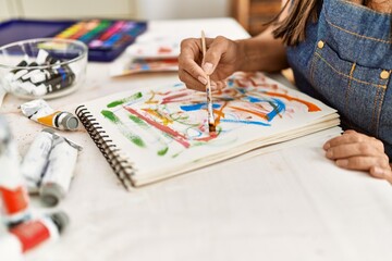 Young hispanic artist woman smiling happy drawing at art studio.