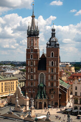 Fototapeta na wymiar Krakow, Poland, July 15th 2022 - St. Mary's Basilica and the market square in the old city center, the view from the Town Hall Tower.