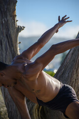 Male Ballet dancer standing in front of a tree on the Pacific Ocean
