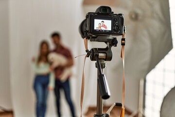 Professional camera taking photo of beautiful couple with dog at photography studio.