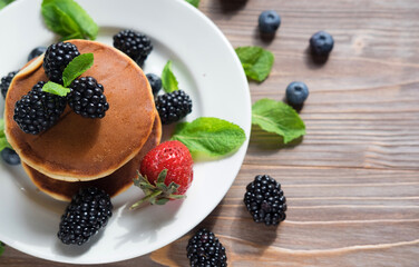 Pancakes for breakfast with blackberries and strawberries.