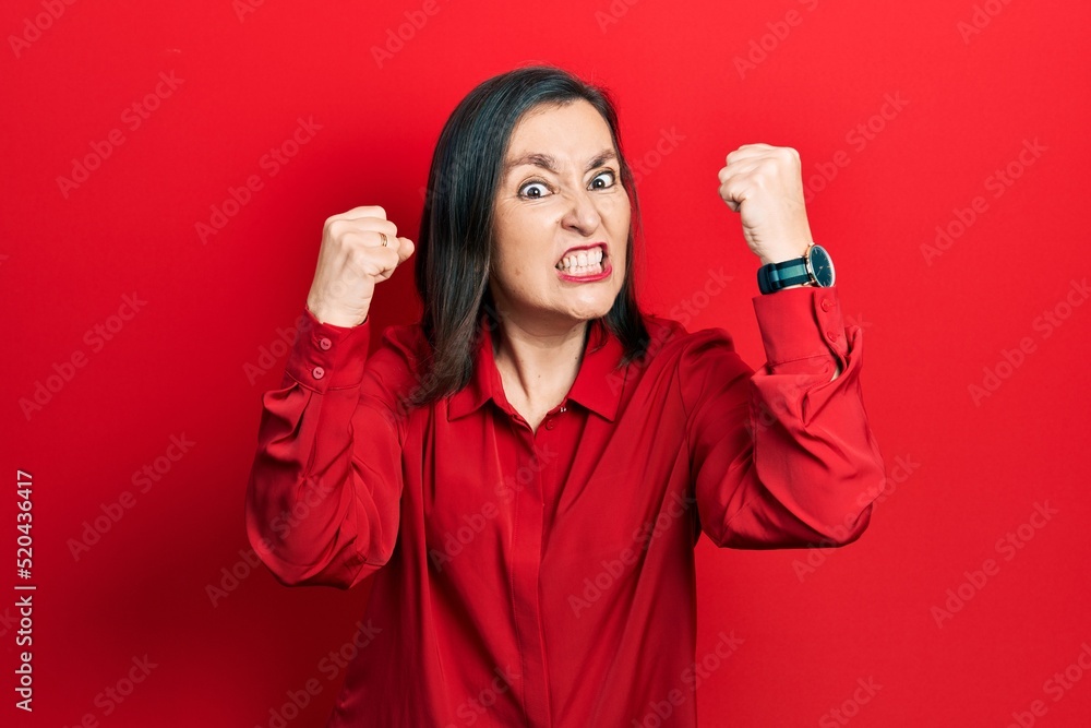 Canvas Prints Middle age hispanic woman wearing casual clothes angry and mad raising fists frustrated and furious while shouting with anger. rage and aggressive concept.