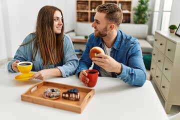 Young caucasian couple having breakfast at home.