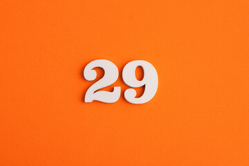 White wooden number 29 on eva rubber orange background