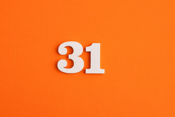 White wooden number 31 on eva rubber orange background