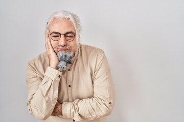 Middle age man with grey hair standing over isolated background thinking looking tired and bored with depression problems with crossed arms.