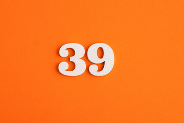 White wooden number 39 on eva rubber orange background