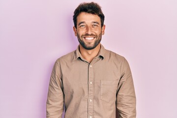 Handsome man with beard wearing casual shirt with a happy and cool smile on face. lucky person.