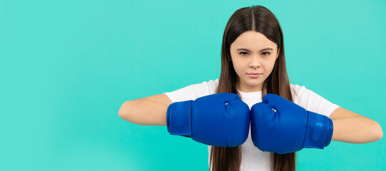 confident child boxer in boxing gloves during sport training, copy space, determination. Horizontal...