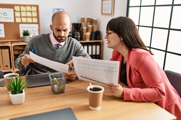 Two hispanic business workers smiling happy working at the office.
