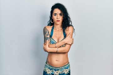 Young woman wearing bindi and traditional belly dance clothes shaking and freezing for winter cold...