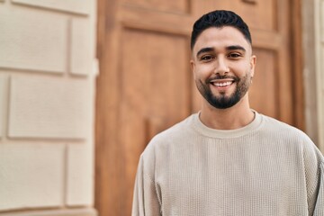 Young arab man smiling confident standing at street