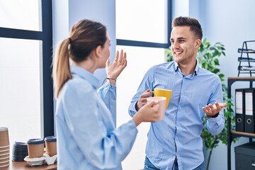 Obraz premium Man and woman business workers drinking coffee at office