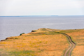 dirt road leading to the edge of a cliff above the water